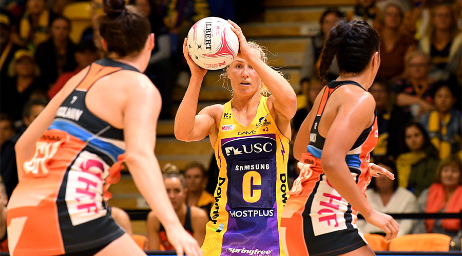 Laura Langman passing the ball surrounded by Giants players