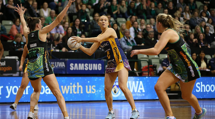 Maddie McAuliffe looking to pass the ball against Fever defenders during the Indigenous round