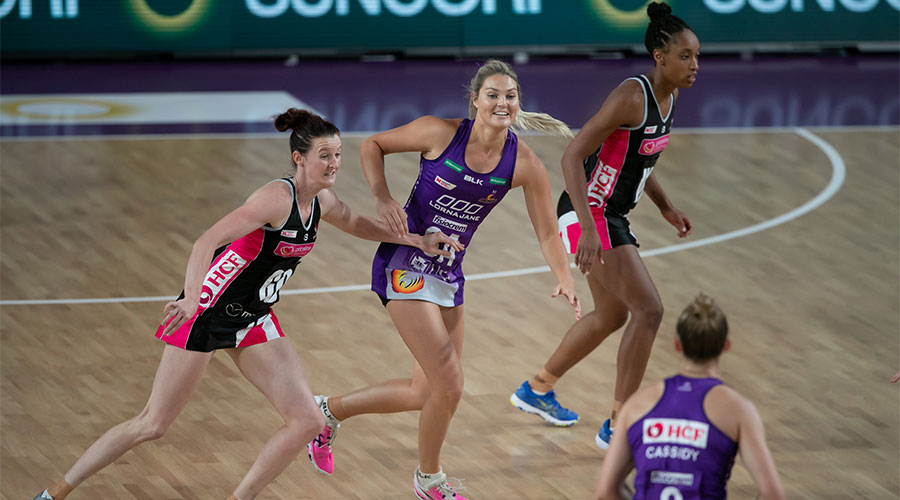 Gretel Tippett running to catch the ball with Kate Shimmin just behind