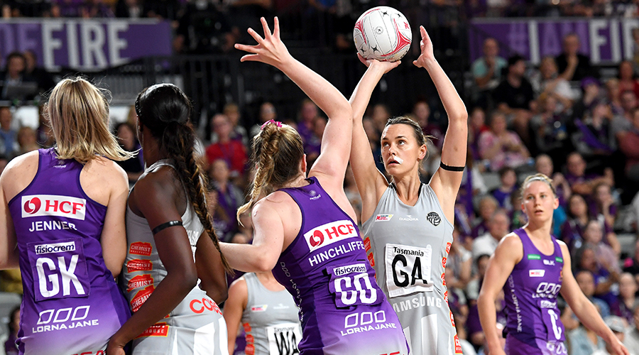 Kim Jenner and Tara Hinchliffe of the Queensland Firebirds contest a shot from Collingwood Magpies shooter Nat Medhurst.