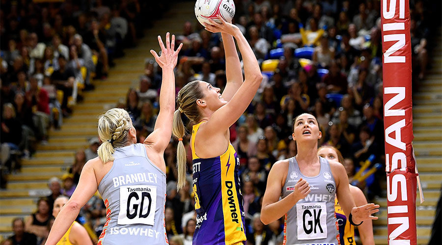 Caitlin Bassett shooting a goal against Magpies defenders April Brandley and Sharni Layton