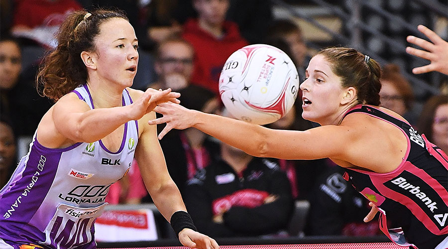 Caitlyn Nevins passing the ball whilst being defended by Thunderbirds players