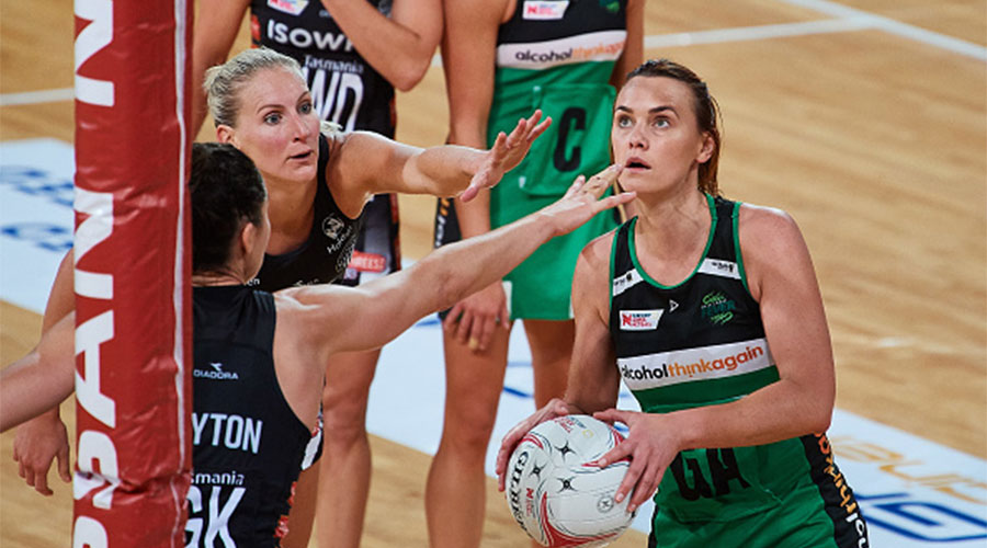 Nat Medhurst trying to score a goal against Magpies defenders April Brandley and Sharni Layton