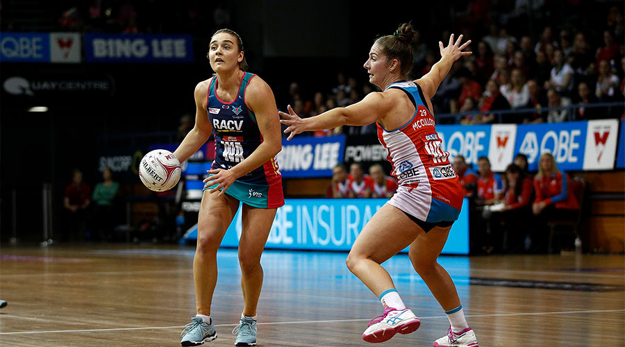 Liz Watson trying to pass the ball whilst being defended by Abbey McCulloch