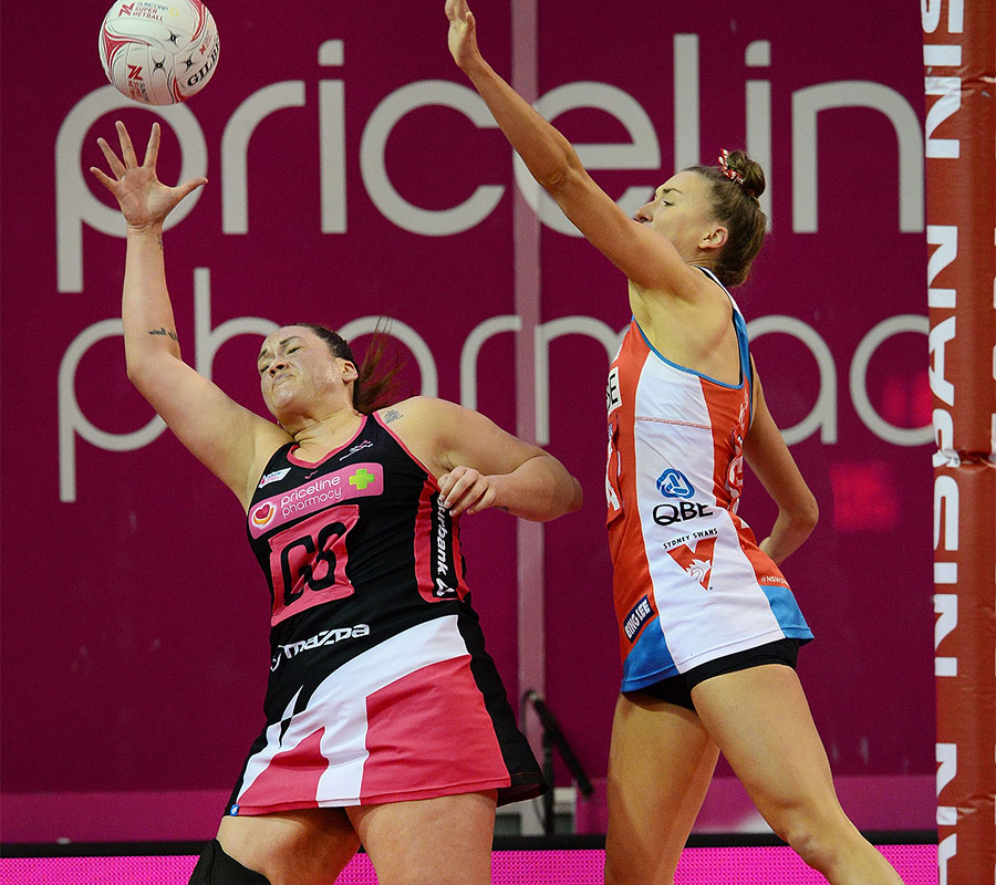 Cat Tuitaviti reaching out for the ball whilst being defended by Sarah Klau